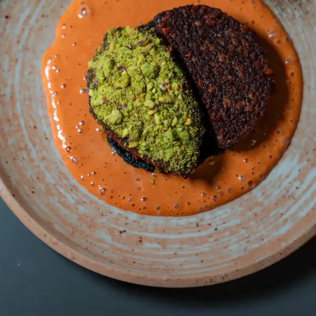 A pistachio-topped small plate in a red sauce at Mirin