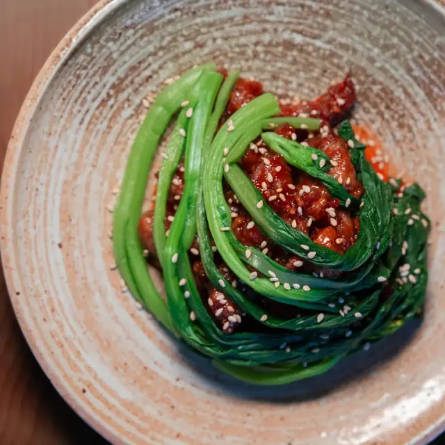 Glossy steamed green vegetables arranged on a plate at Mirin